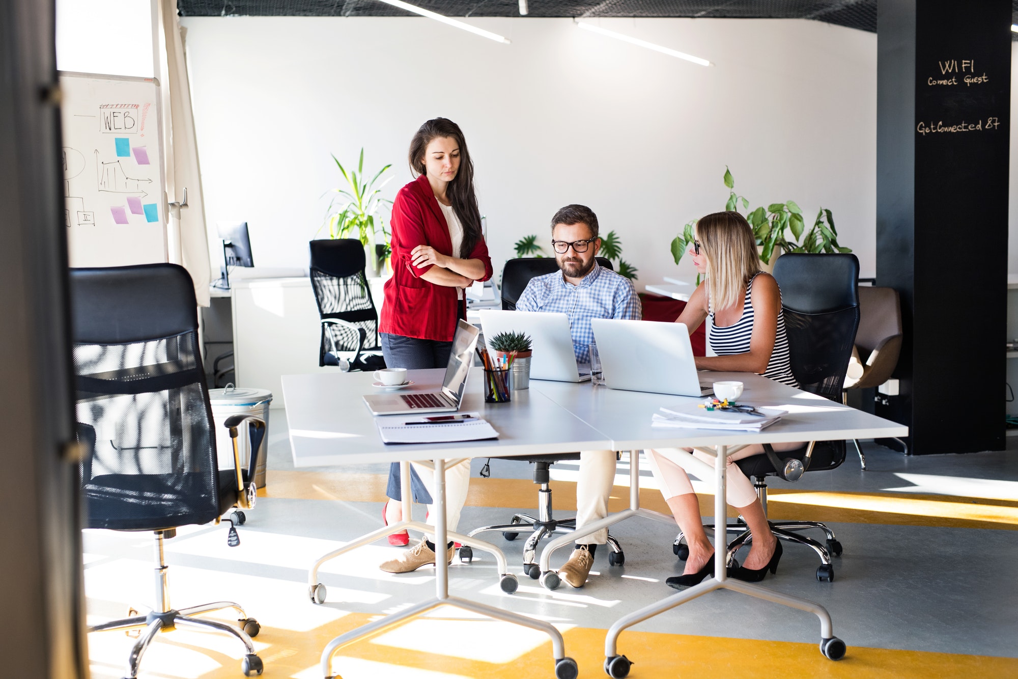 Three business people in the office talking together.